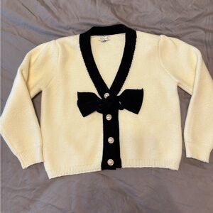 Stellah Contrast Bow Cardigan, cream-colored with black bow and pearl buttons